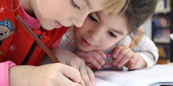 Dos niñas escriben en un cuadernos 