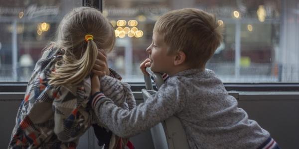 Dos niños mirando por una ventana