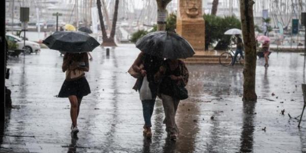 Transeúntes se protegen de las fuertes lluvias 