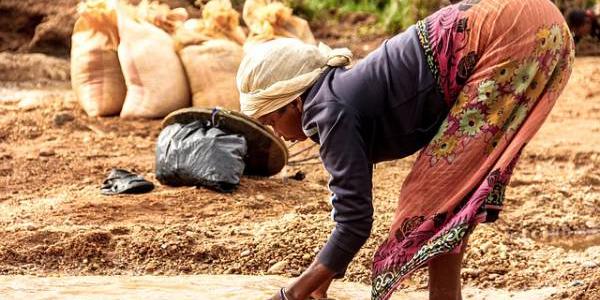 Niña recogiendo agua sucia en África