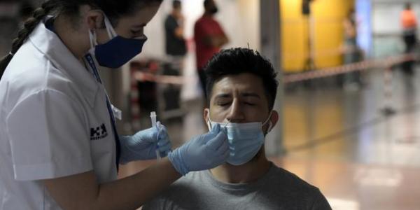 Una sanitaria realiza un test de antígenos a un hombre en Madrid