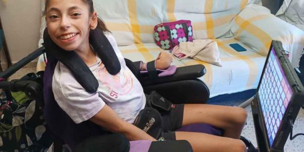 Laura Caño sonríe junto a su lector de ojos | Foto cedida por la familia