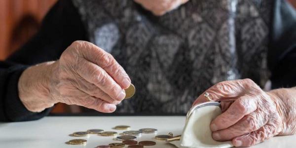 Manos de una persona mayor contando dinero