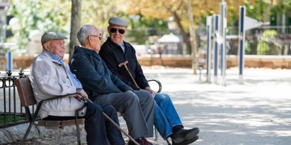 Tres jubilados sentados en un banco.