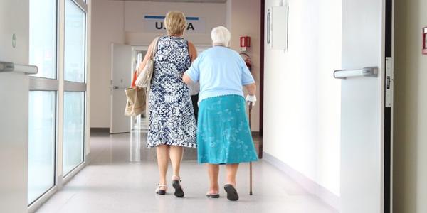 Una persona mayor y su acompañante en un hospital