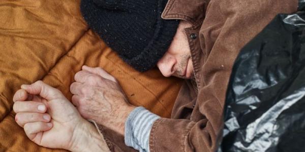 Un hombre sin vivienda duerme en el suelo