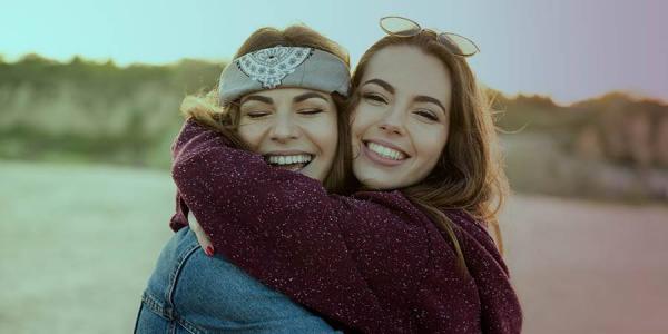 Amigas abrazándose y sonriendo