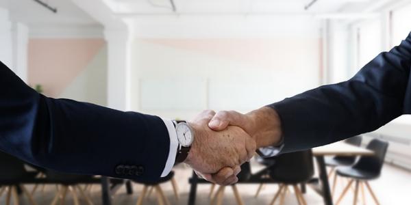 Dos manos de empresarios cerrando un acuerdo