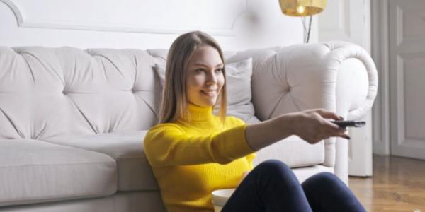 Chica en el salón de su casa viendo la televisión