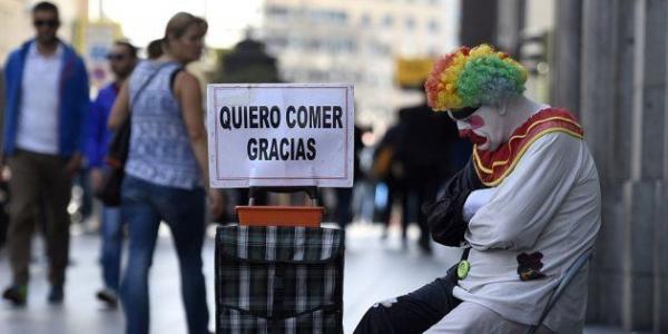 Una persona sujeta un cartel en español: "quiero comer, gracias". 