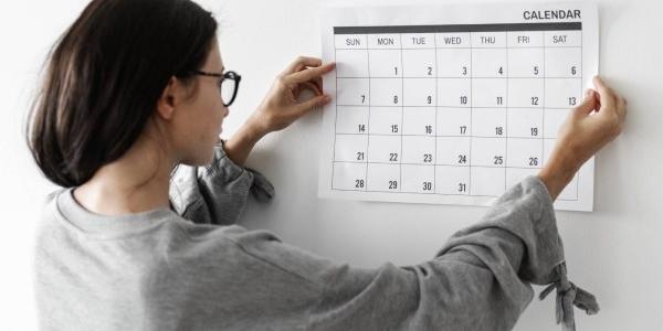 Chica colgando un calendario