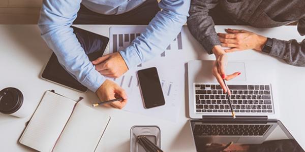 Dos personas trabajando en una pyme con sus ordenadores