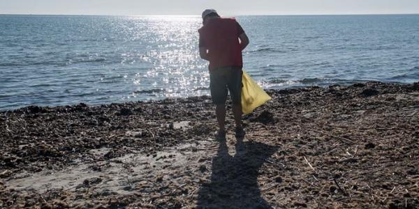 Voluntario recogiendo basuraleza en un playa española