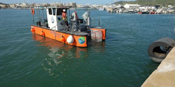 Uno de los barcos que realiza la retirada de residuos en el puerto de Ibiza