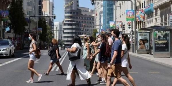 Personas cruzando la Gran Vía de Madrid