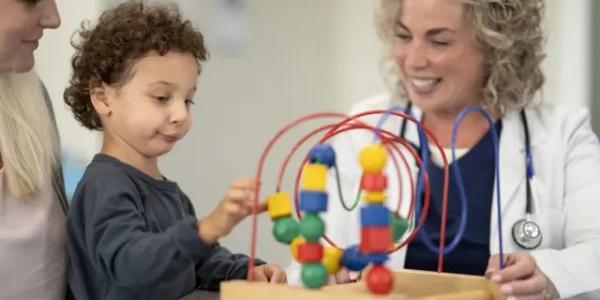 Un pediatra observa a un niño con retraso madurativo