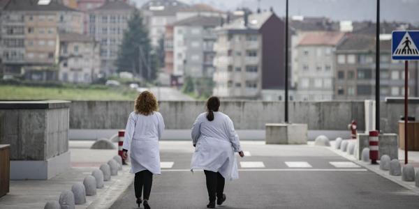 En pareja dos doctores caminan en las inmediaciones de un hospital 