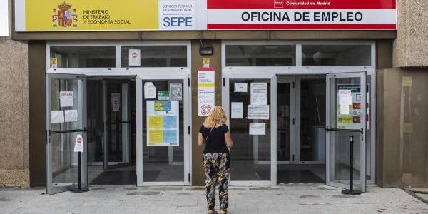 Una mujer a las puertas de una oficina del SEPE y oficina de empleo