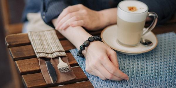 Mujer tomando un café junto a su portátil