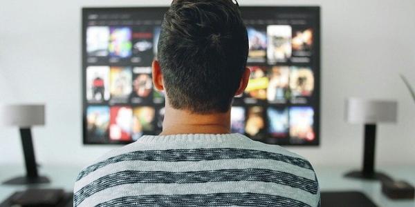 Un hombre sentado en su salón frente al televisor