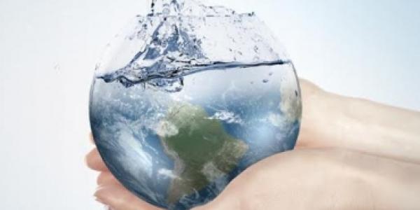 Manos sujetando el mundo con agua
