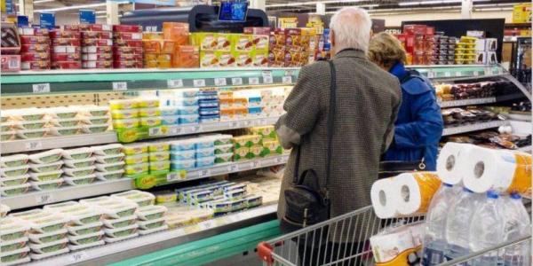 Una persona con mascarilla comprando en en supermercado físico /El Cronista