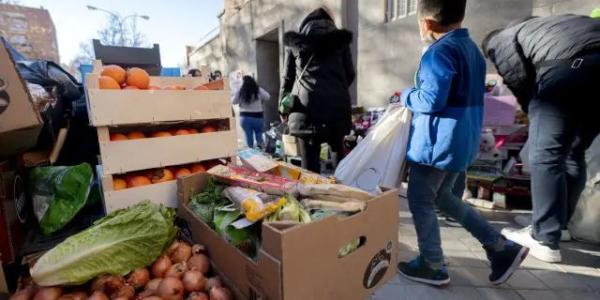 Personas en riesgo de exclusión acuden a recoger alimentos, en la plaza de San Amaro, a 7 de enero de 2022, en Madrid (España)