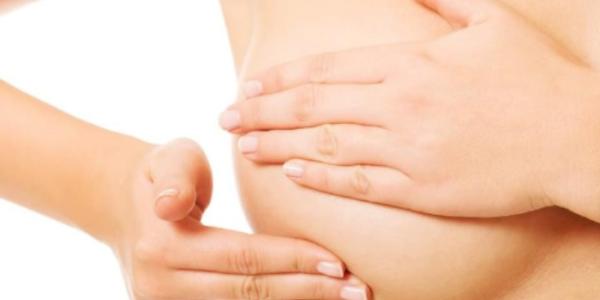 Una mujer haciéndose una autoexploración en la mama