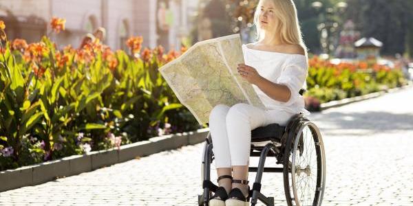 Una mujer con discapacidad consulta el mapa de la ciudad de una ciudad europea 