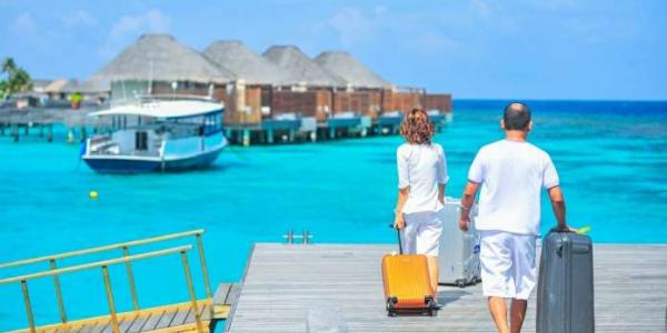 Una familia contempla una playa mientras tiran de sus maletas 