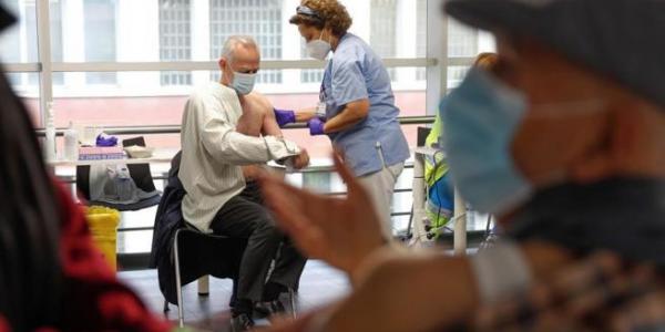 Varias personas reciben sus respectivas dosis de vacuna en el Wizink Center de Madrid. EMILIO NARANJO / EFE