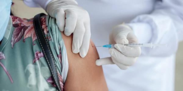 Persona inyectándose vacuna covid