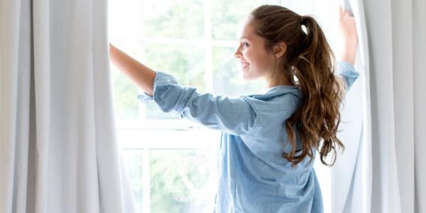 Chica abriendo ventanas para ventilar en una casa / Pixabay