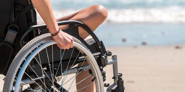 Persona en silla de ruedas en la playa 