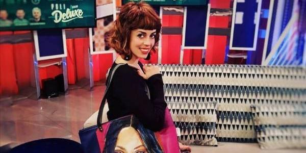 La diseñadora y artista Victoria Picazo con uno de sus bolsos en gesto sonriente 