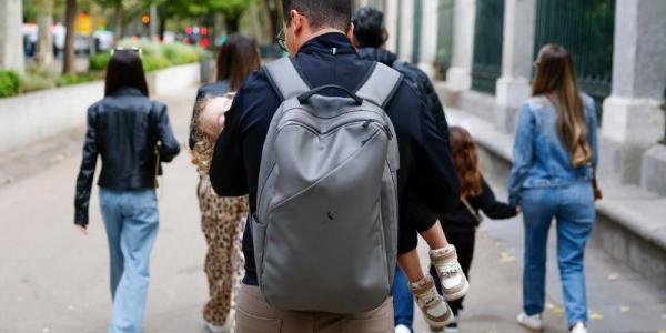 Fotografía de archivo de una familia recorriendo el paseo del Prado (Madrid). 